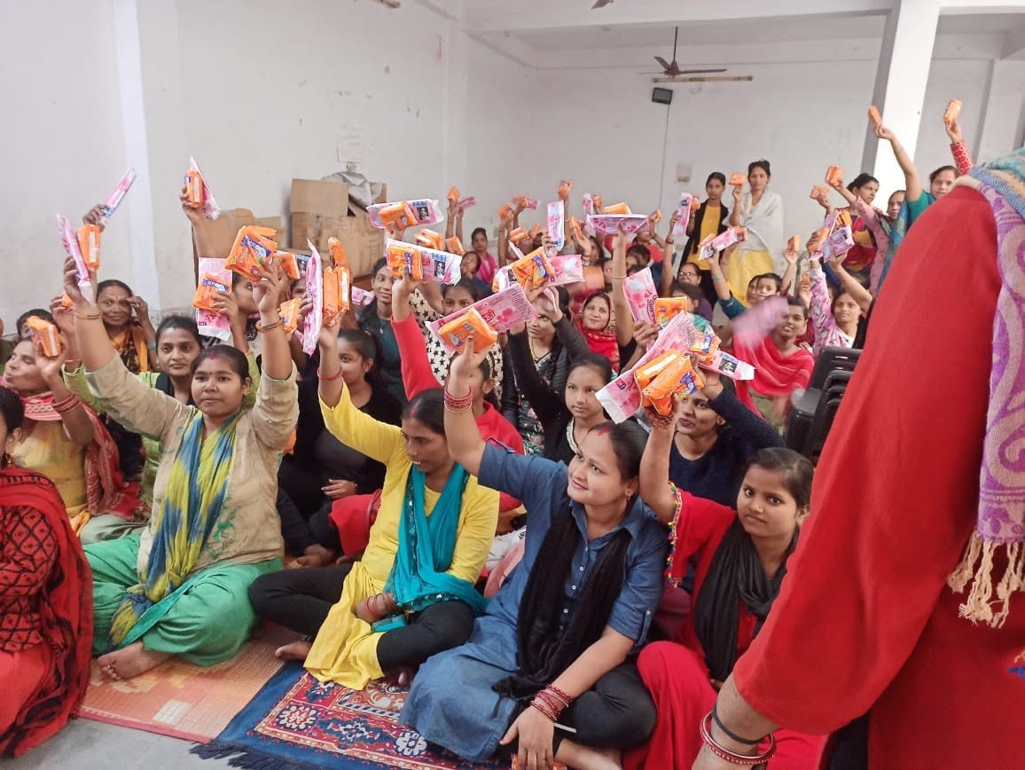 Women raising hygiene kits at a community drive