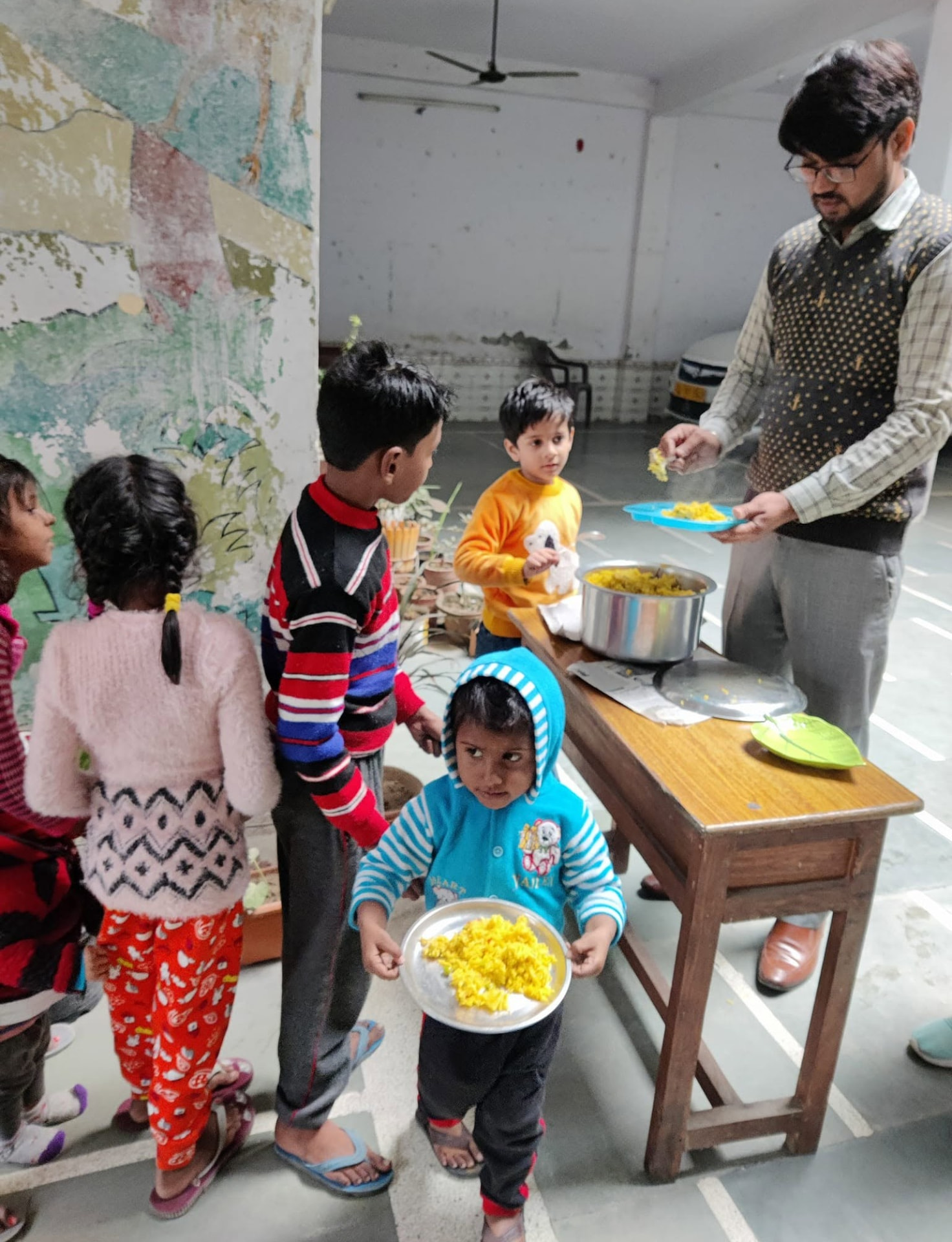Volunteer serving food to children during a community distribution drive